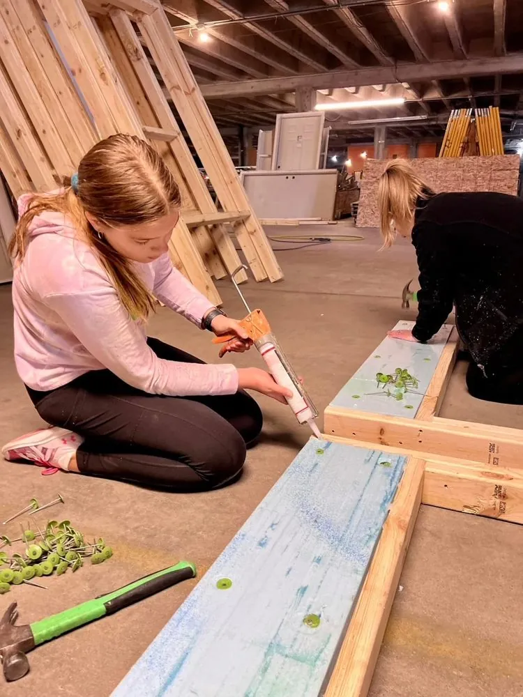 Eliana caulking a wooden project